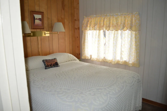 The south bedroom with queen bed, heated mattress pad, and small chest of drawers.